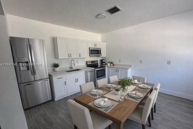 6875 Northwest 4th Avenue, Unit B Miami, FL 33150 - Photo 2 of 5 a kitchen with stainless steel appliances granite countertop a refrigerator a stove a sink a dining table and chairs