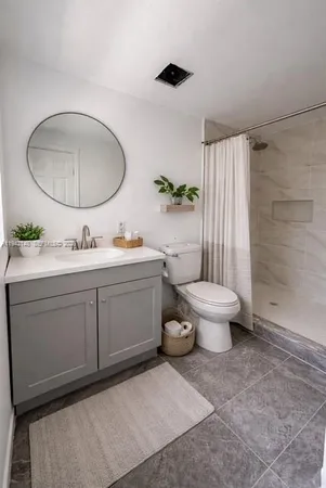 a spacious bathroom with a toilet sink and mirror