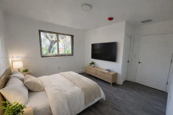 a bedroom with two beds and a flat screen tv