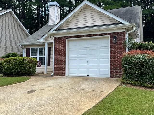 a small white house with a white roof and wooden fence