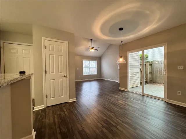 a view of a hallway with wooden floor and a bathroom