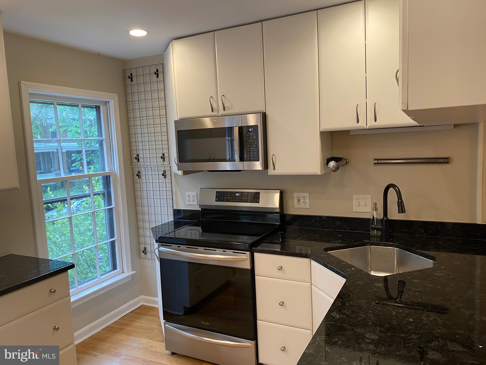 339 11th Street Southeast Washington, DC 20003 - Photo 21 of 39 a kitchen with granite countertop white cabinets stainless steel appliances and a sink