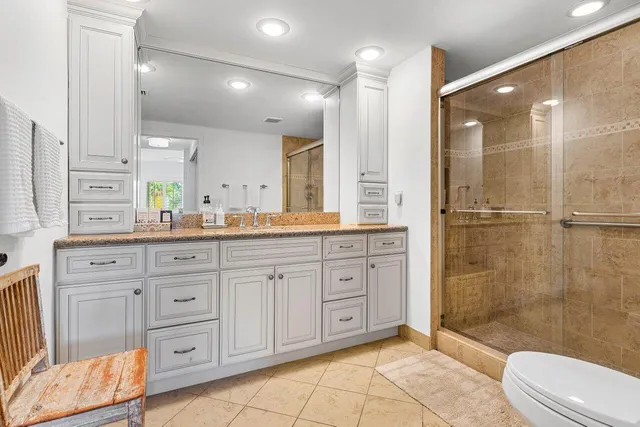 a spacious bathroom with a granite countertop sink mirror and shower