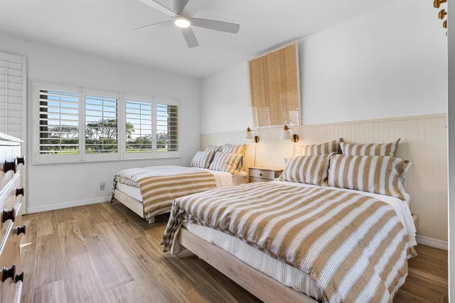 a bedroom with two beds and a large window
