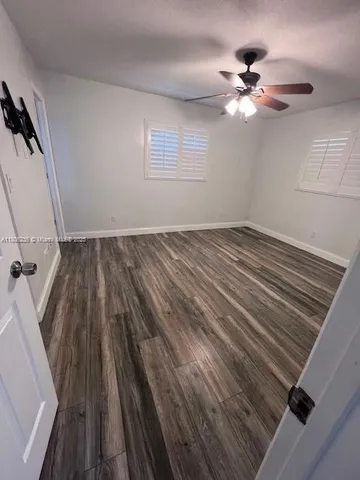a view of a livingroom with wooden floor and a ceiling fan