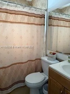 a white toilet sitting next to a shower curtain