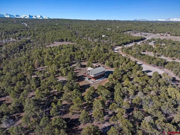an aerial view of residential house with parking and mountain view