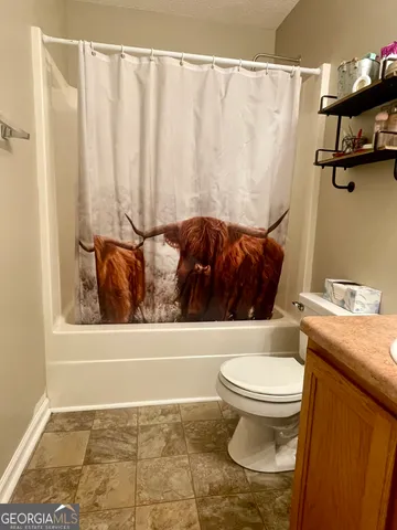 a bathroom with a toilet and a shower curtain
