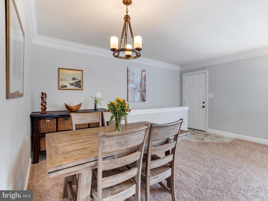 132 Oakwood Road Edgewater, MD 21037 - Photo 6 of 37 a dining room with wooden floor a chandelier a wooden table and chairs