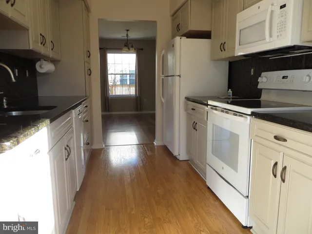 a kitchen with white cabinets and white appliances
