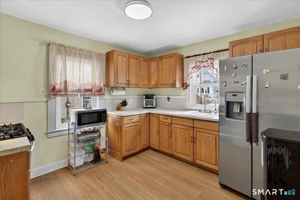 a kitchen with a refrigerator a stove top oven a sink and a window