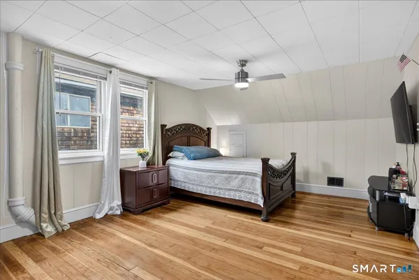 a bedroom with furniture and a flat screen tv