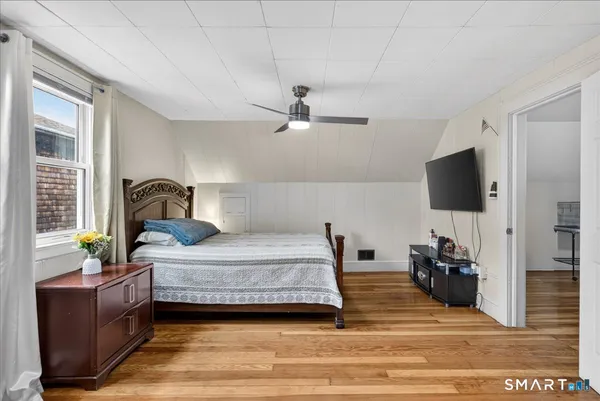a bedroom with a bed and a flat tv screen on the dresser