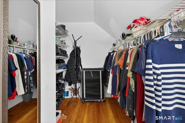 a view of walk in closet with clothes and shoes