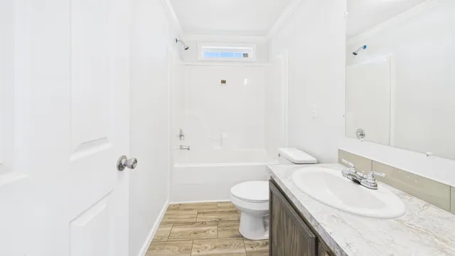 a bathroom with a granite countertop sink toilet a mirror and shower