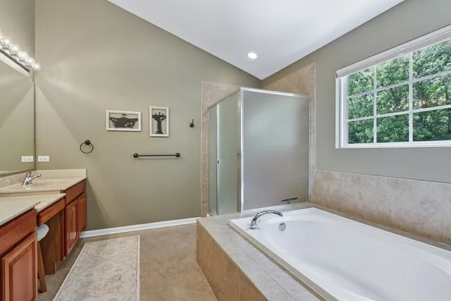 a bathroom with a tub a sink and mirror