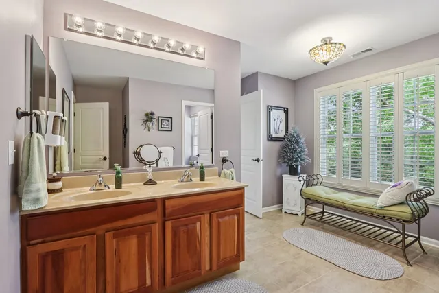 a spacious bathroom with double vanity and a mirror