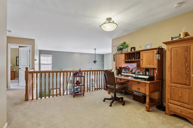 a view of a workspace with furniture and a window