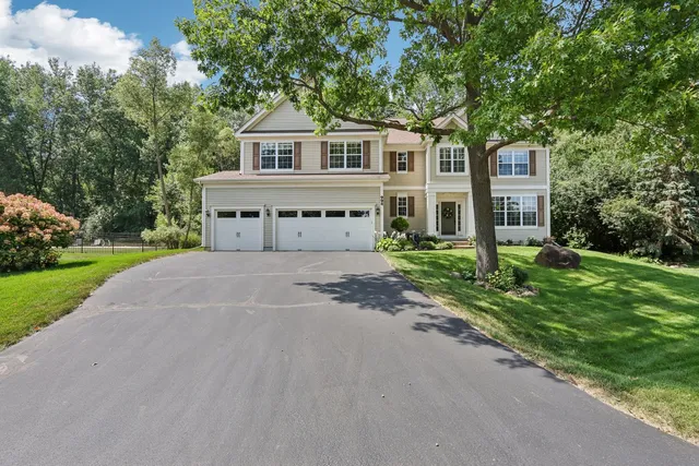a front view of a house with a yard and trees