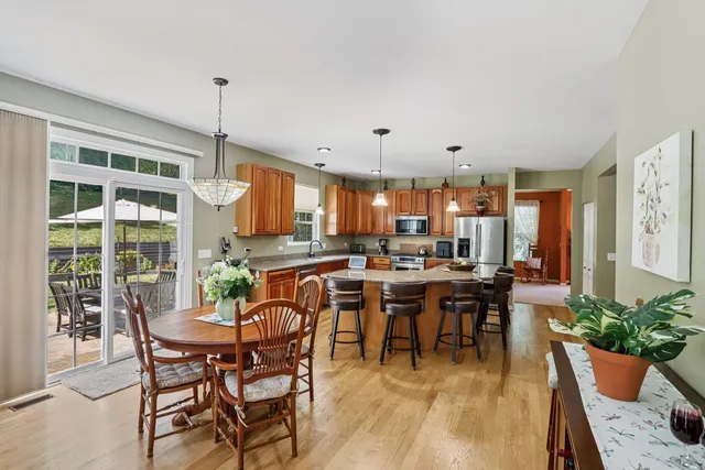 a view of a dining room and livingroom with furniture wooden floor a chandelier