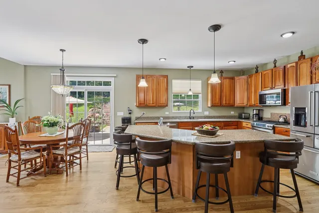 a kitchen with stainless steel appliances a stove a table and chairs in it