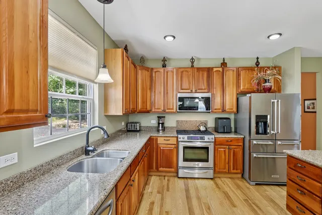 a kitchen with stainless steel appliances granite countertop a stove a sink and a microwave