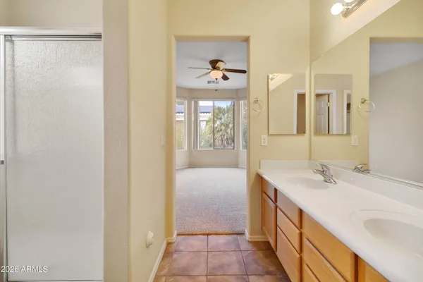 a en suite bathroom with a granite countertop sink a mirror and a bathtub