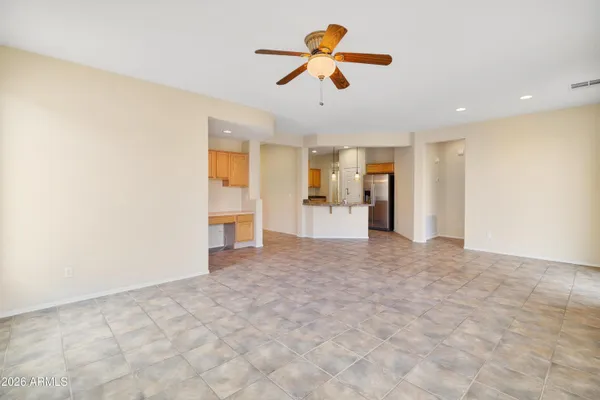 a view of empty room with wooden floor and ceiling fan