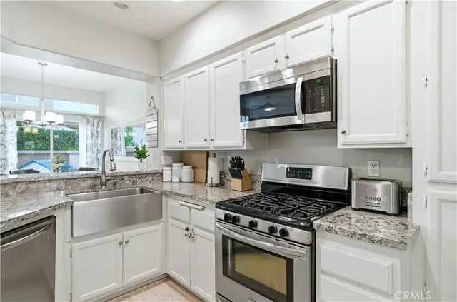 a kitchen with stainless steel appliances white cabinets and a stove top oven