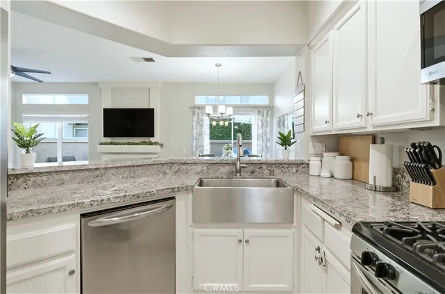 a kitchen with stainless steel appliances granite countertop a sink stove and microwave