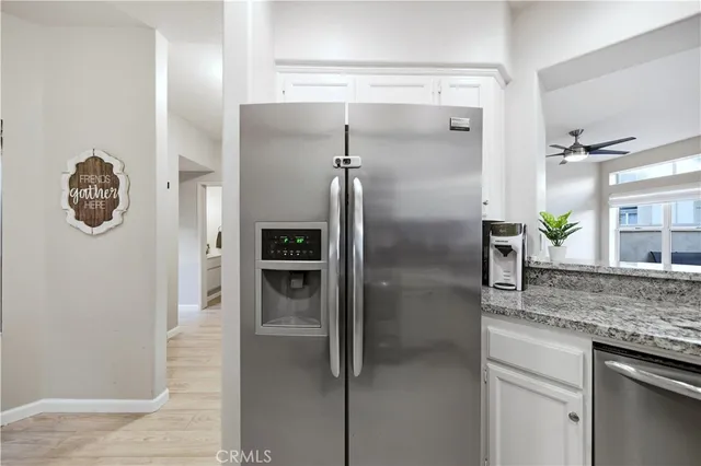 a kitchen with granite countertop a refrigerator and a sink
