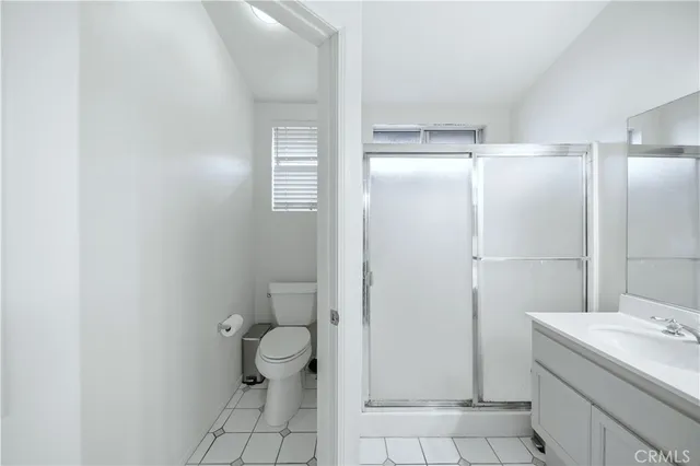 a bathroom with a granite countertop sink a toilet and a shower