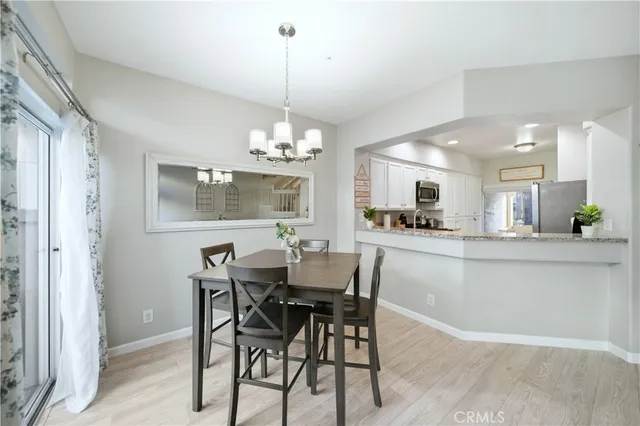 a view of a dining room with furniture a chandelier and wooden floor