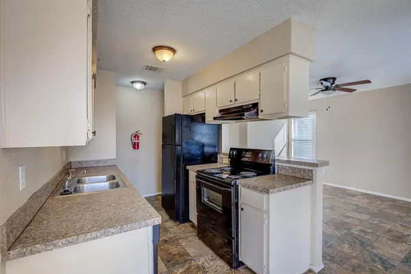 a kitchen with a stove a refrigerator and a sink