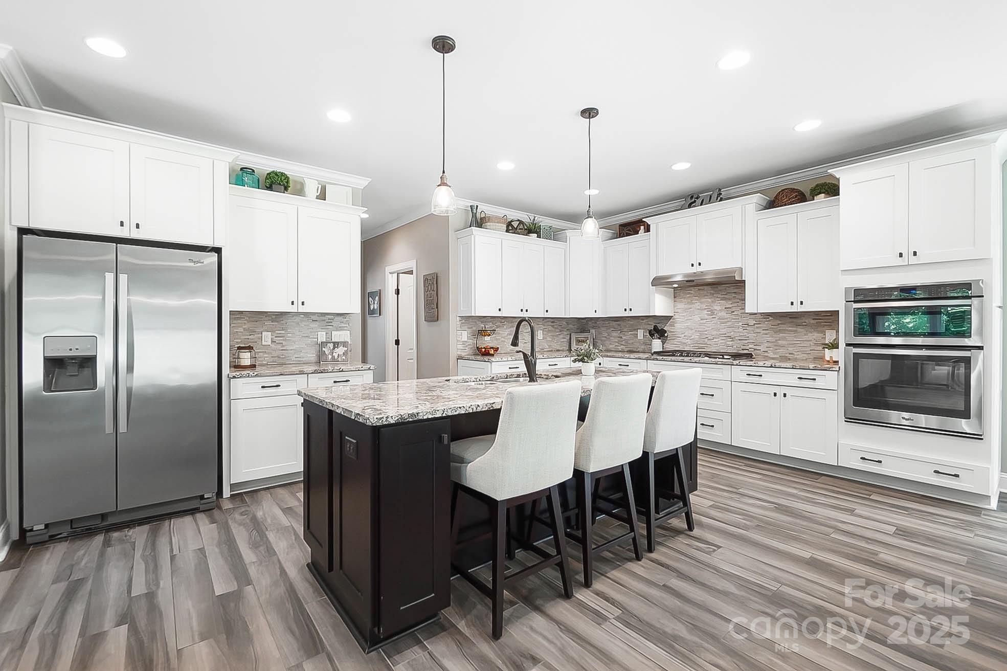 7219 Indian Trail Fairview Road Indian Trail, NC 28079 - Photo 20 of 48 a kitchen with kitchen island granite countertop a sink a center island stainless steel appliances and cabinets