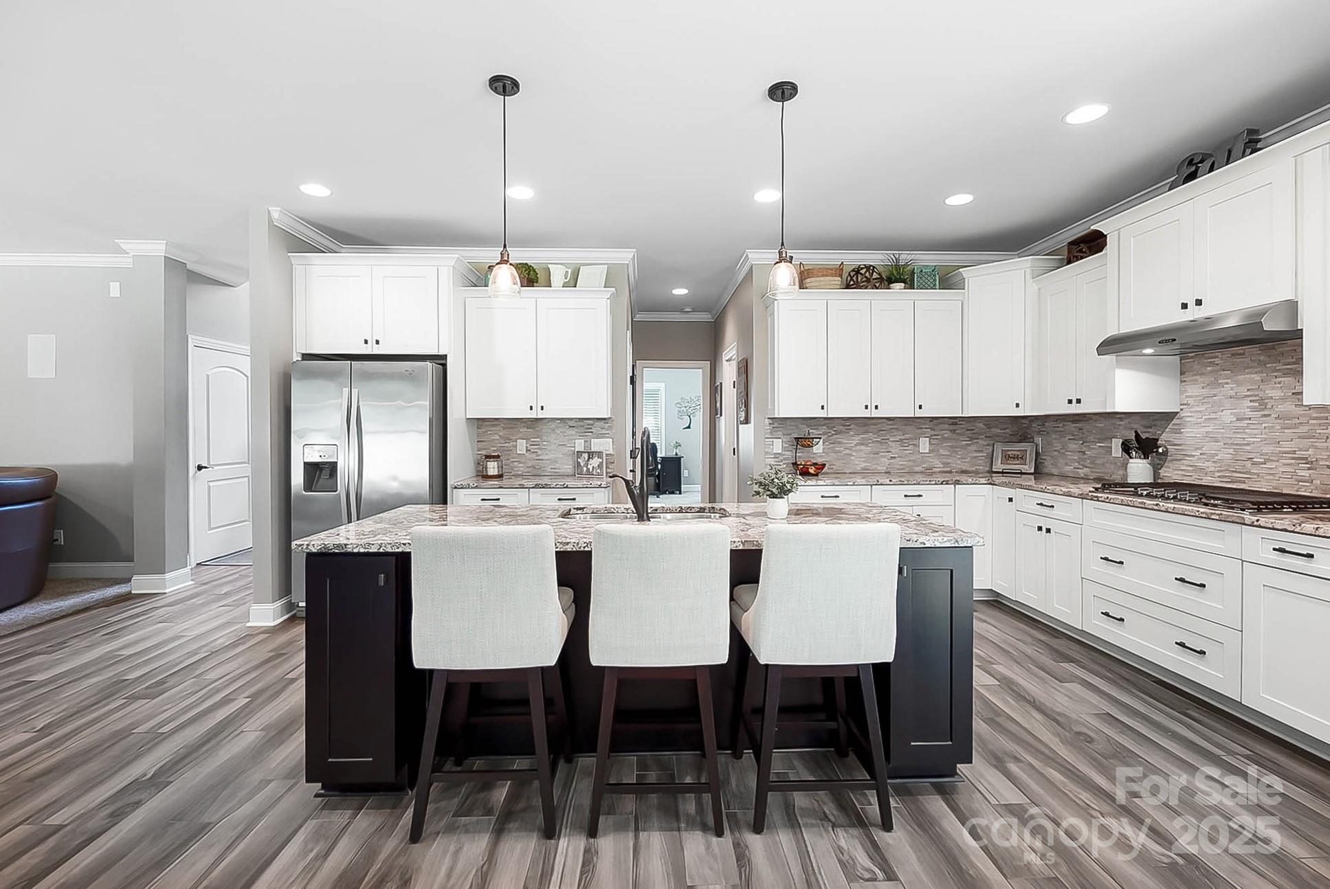 7219 Indian Trail Fairview Road Indian Trail, NC 28079 - Photo 23 of 48 a kitchen with stainless steel appliances granite countertop a dining table chairs stove refrigerator and cabinets