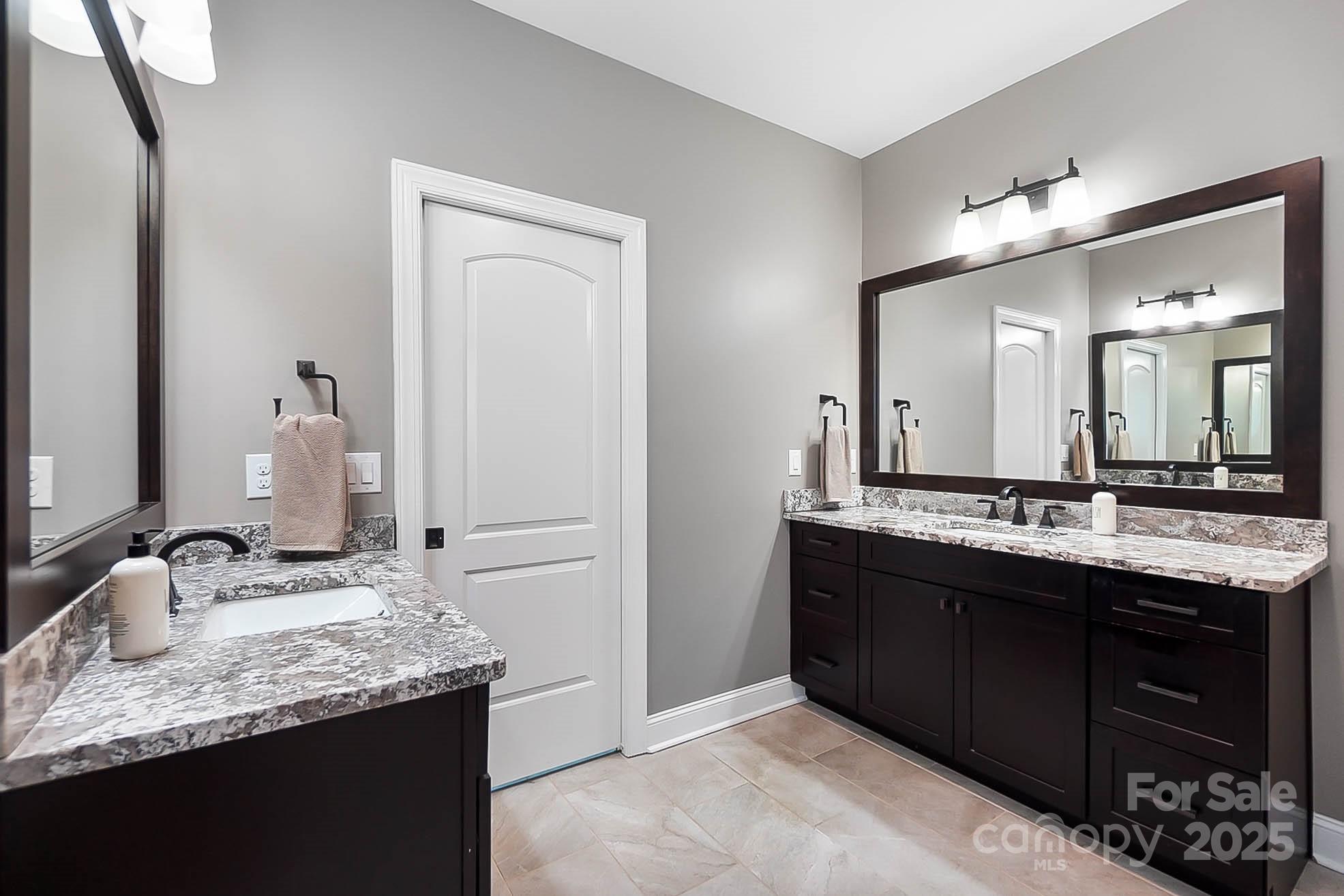 7219 Indian Trail Fairview Road Indian Trail, NC 28079 - Photo 33 of 48 a bathroom with a granite countertop double vanity sink and a mirror