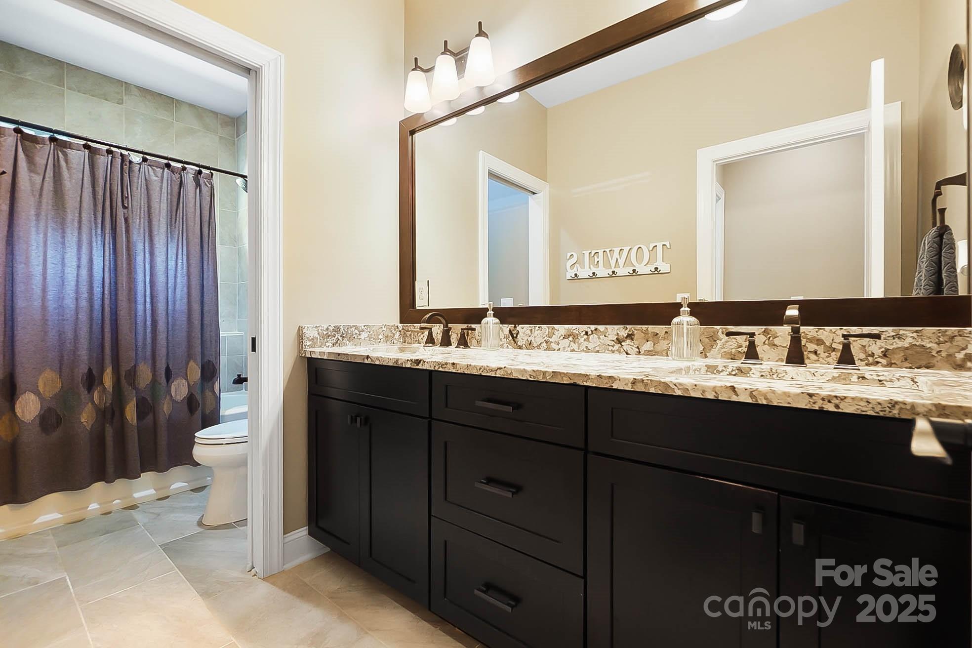 7219 Indian Trail Fairview Road Indian Trail, NC 28079 - Photo 40 of 48 a bathroom with a granite countertop sink and a mirror