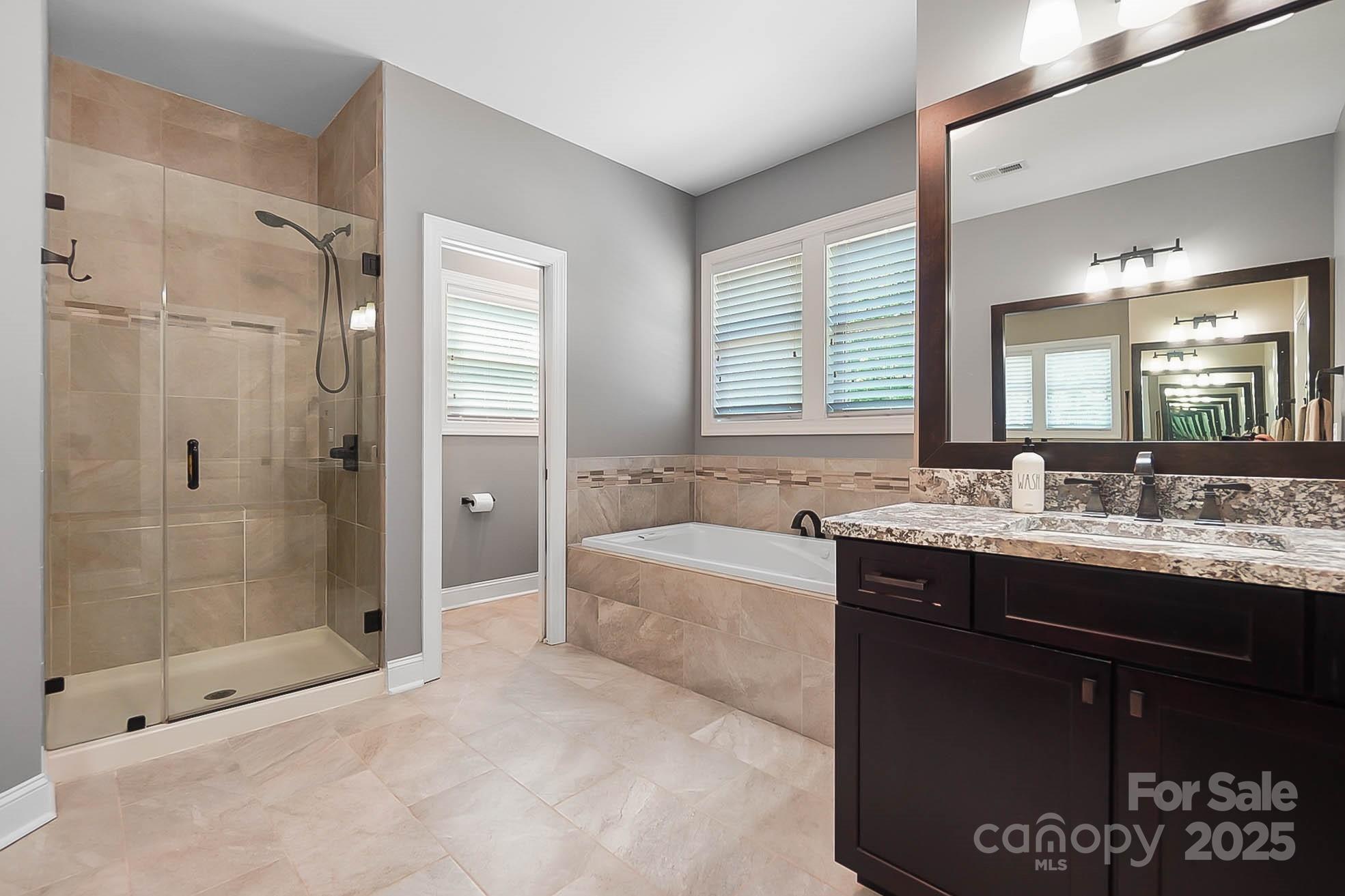7219 Indian Trail Fairview Road Indian Trail, NC 28079 - Photo 10 of 48 a bathroom with a granite countertop tub sink shower and mirror