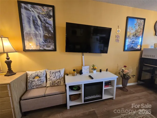 a bedroom with a bed a dresser and potted plants next to a window