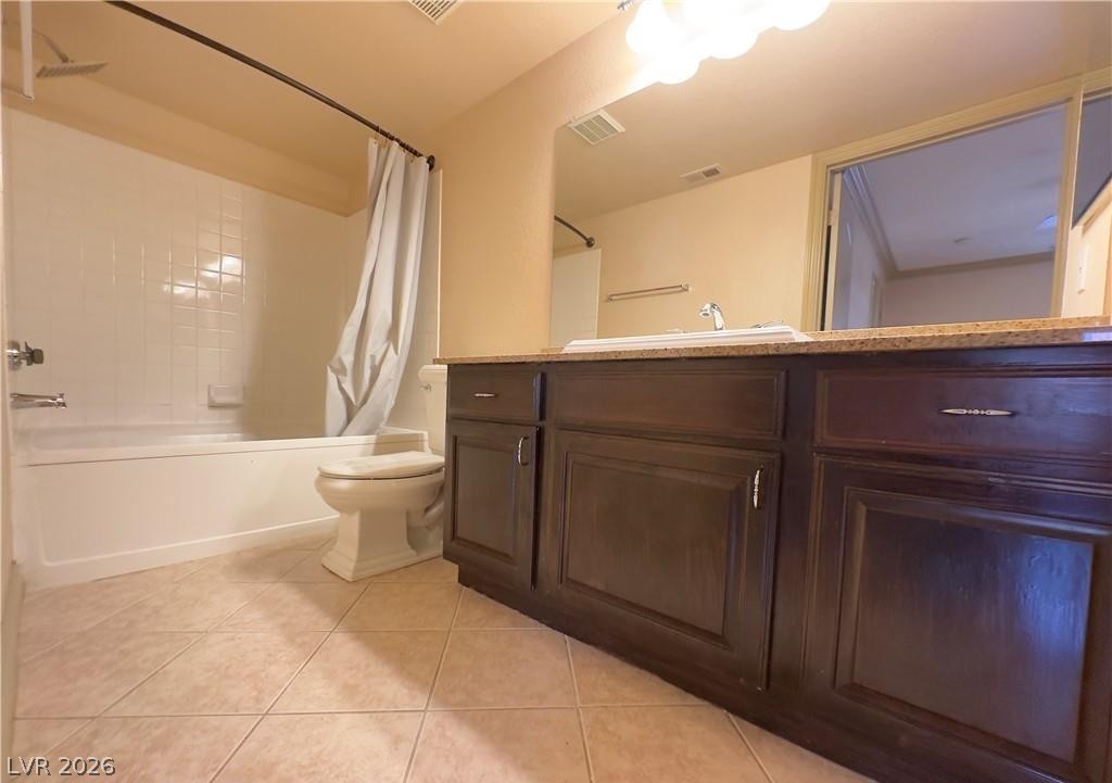 8101 West Flamingo Road, Unit 1082 Las Vegas, NV 89147 - Photo 13 of 23 A compact bathing area featuring an integrated shower-tub combination, practical vanity storage, and tiled flooring.