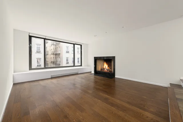 an empty room with wooden floor and fireplace