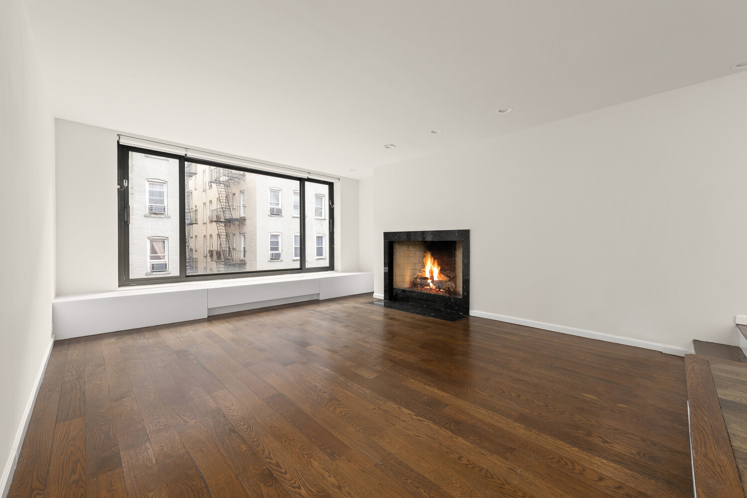 an empty room with wooden floor and fireplace