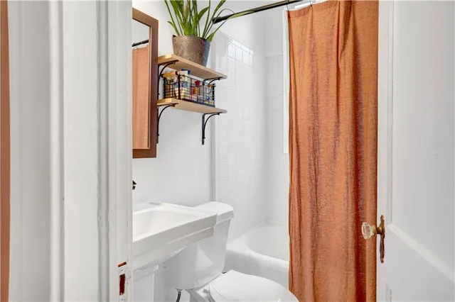 a bathroom with a toilet and a shower curtain