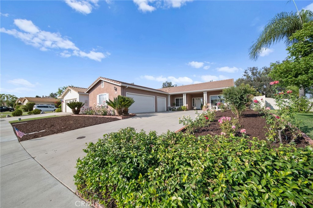 a front view of a house with a yard and potted plants