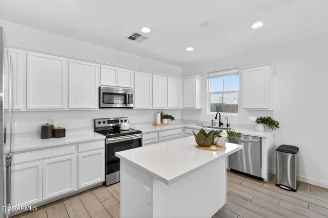 a living room with furniture kitchen view and a window