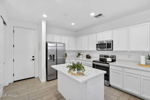 a kitchen with white cabinets and appliances