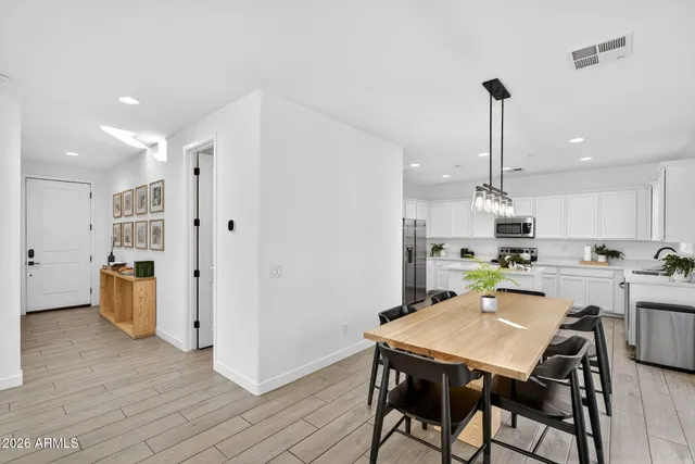 a kitchen with refrigerator a sink and chairs