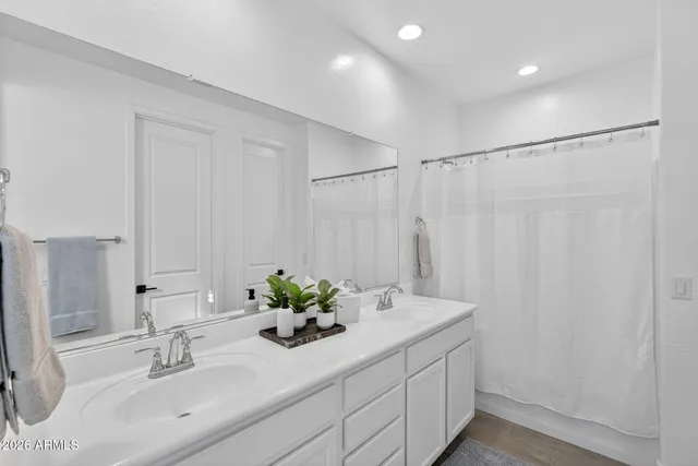 a bathroom with a bathtub shower sink and mirror