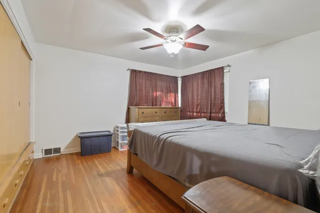 a bed sitting in a spacious bedroom next to a window